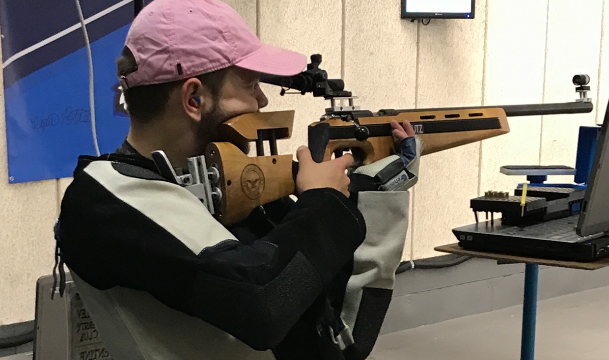 Rifle athlete lines rifle for the shot for virtual match.